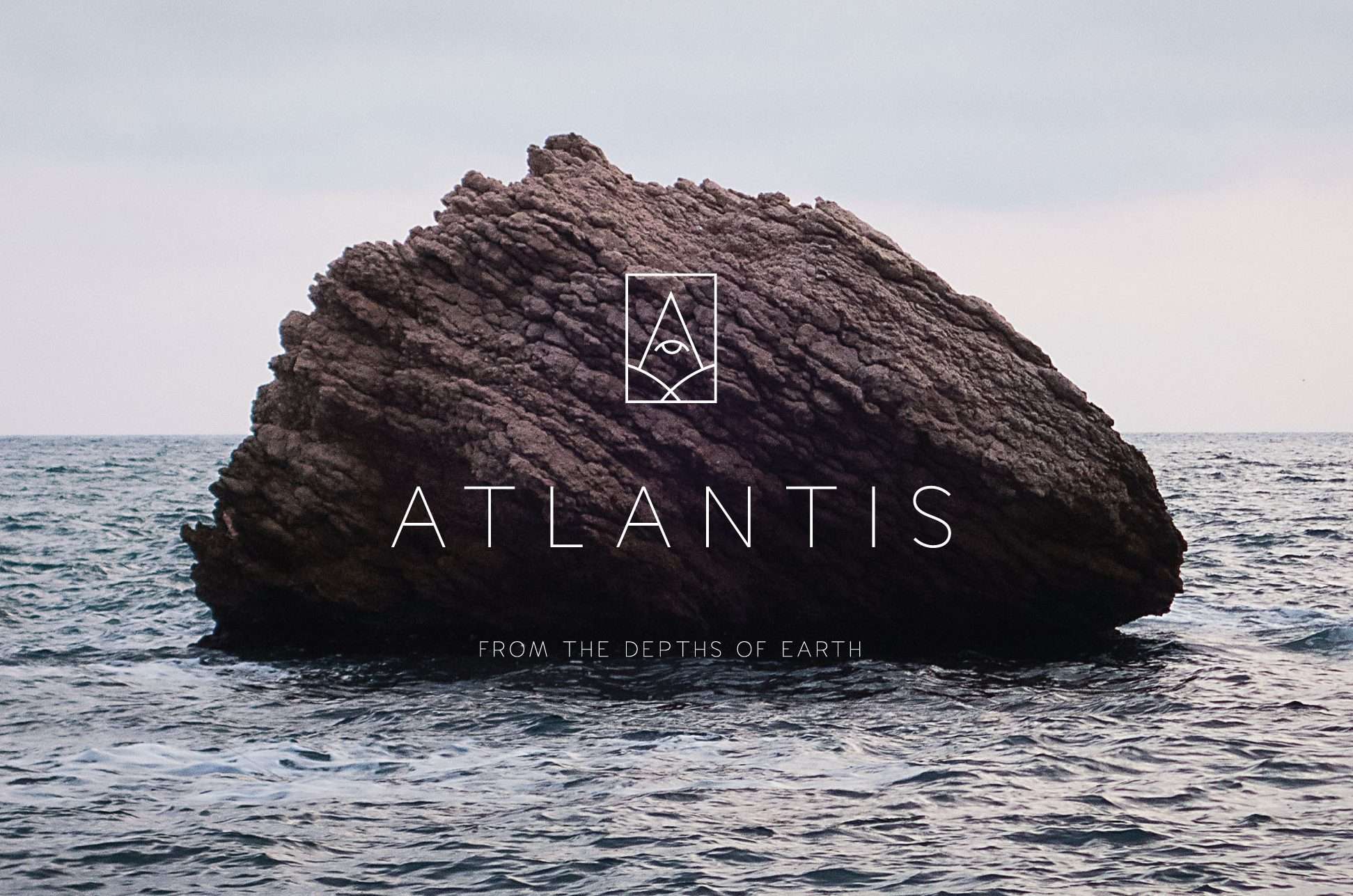Logo design for Atlantis. The logo is superimposed over an image of a rock jutting out of the sea.